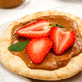 A pita with strawberries and a chocolate hazelnut spread.